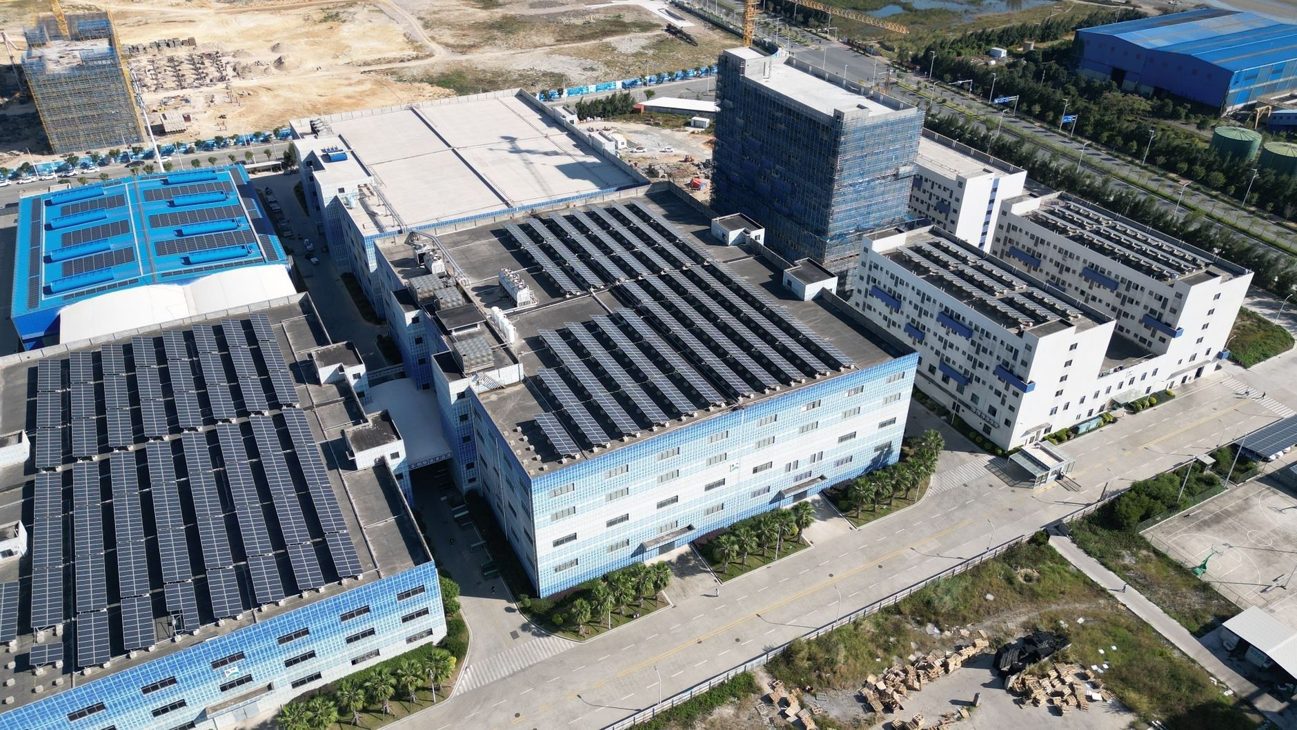 Drohnenaufnahme einer Industrieanlage mit zahlreichen Solarmodulen auf den Dächern